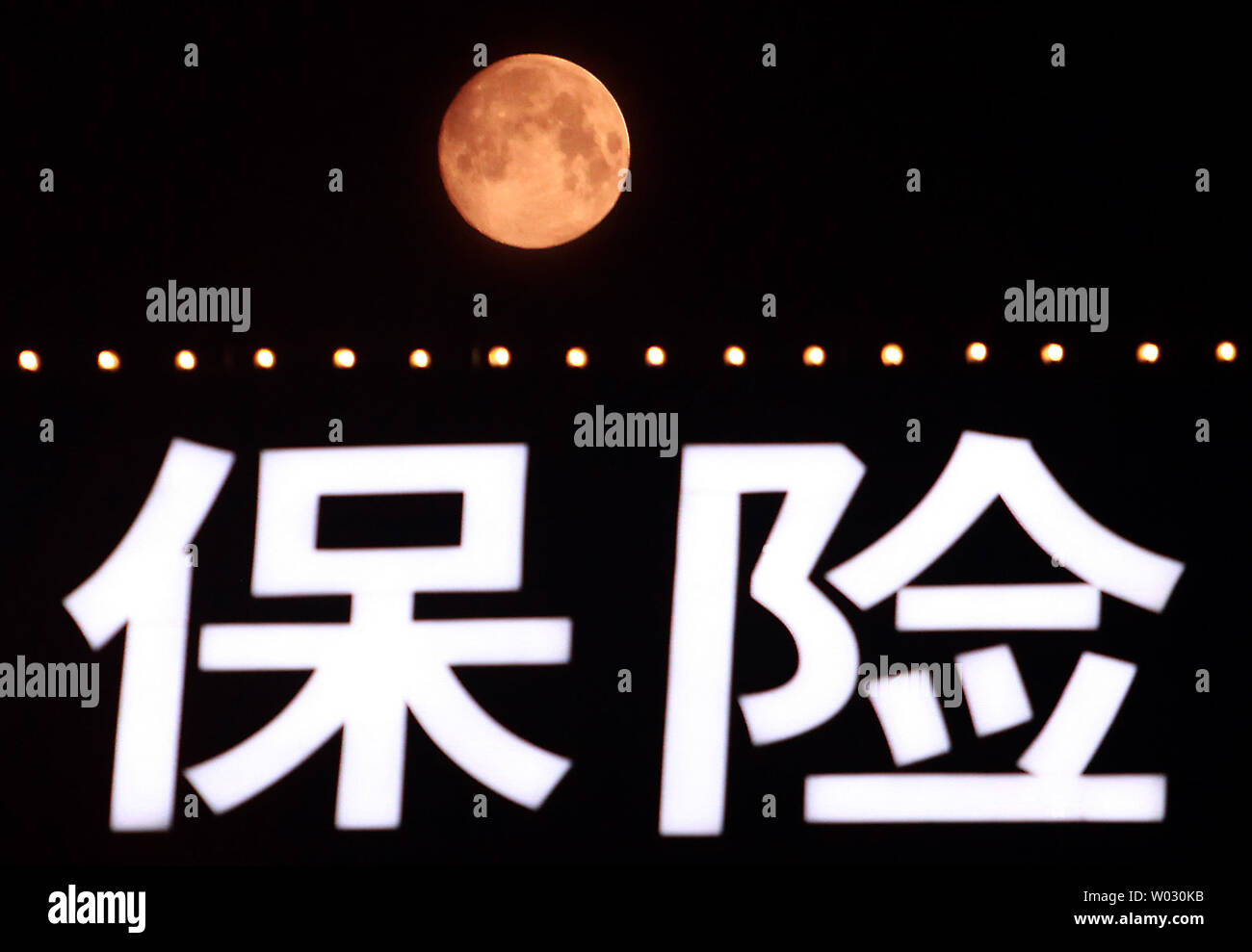The start of a rare "blue moon," which is red due to the pollution in the atmosphere, rises over Beijing on August 30, 2012.  Called "blue" due the rarity of it, the "blue moon" occurs when there's a second full moon in one calendar month, with the next one not happening until July 2015.  U.S. astronaut Neil Armstrong's family has suggested paying tribute to the first man on the moon by looking up at the moon and giving the astronaut a wink.    UPI/Stephen Shaver Stock Photo