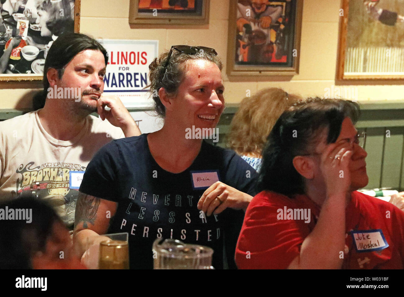 Wheaton, Illinois, USA. 26th June, 2019. Wednesday, June 26, 2019 - Wheaton, Illinois, U.S. - Senator Elizabeth Warren supporters STEVE ERICKSON, form left, ALICIA ERICKSON and JULIE MOSKAL watch the First Democratic Presidential Debate at Gino's East restaurant in Wheaton, Illinois during a watch party sponsored by grass roots organization Indivisible DuPage. Credit: H. Rick Bamman/ZUMA Wire/Alamy Live News Stock Photo