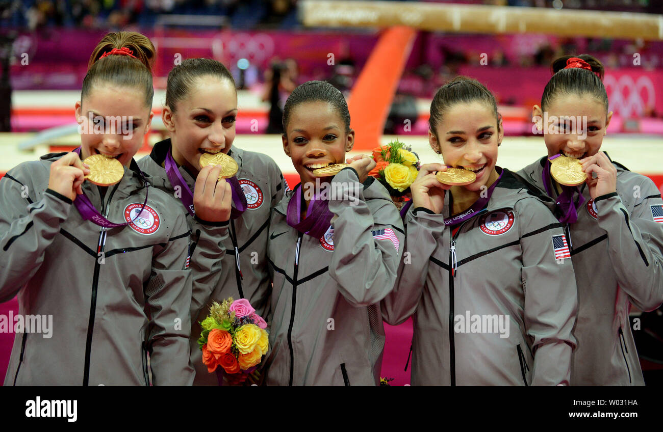 The United States Gymnastics Team Is All Smiles As They Bite Into Their Gold Medals After Winning The Women S Gymnastics Team Event At The North Greenwich Arena During The London 12 Summer