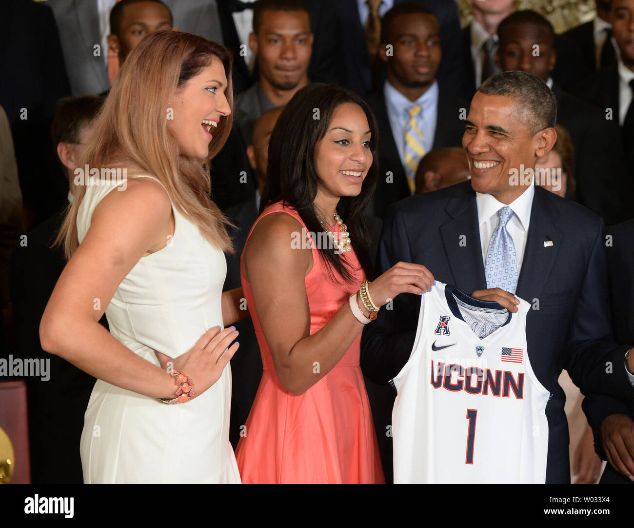 U.S. President Barack Obama receives a jerseys from Stefanie Dolson (L) and  Bria Hartley of the University of Connecticut women's basketball team  during a presentation in the East Room of the White