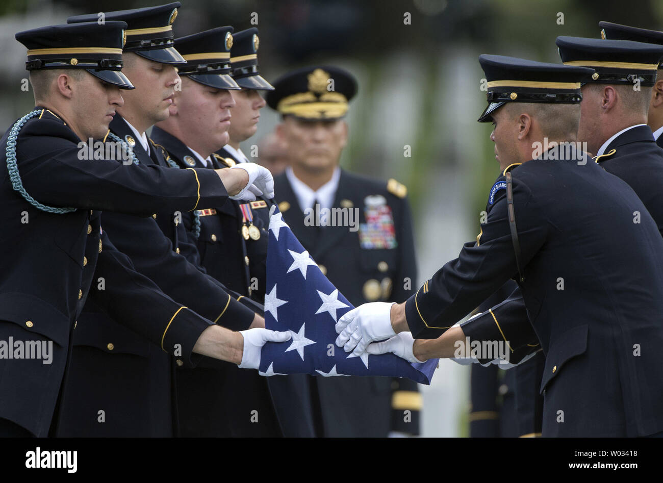 An Army Honor Guard prepares a flag to be presented to Susan Myers, the widow of Army Maj. Gen. Harold J. Greene, during Greene's graveside service at Arlington National Cemetery on August 14, 2014 in Arlington, Virginia. Greene was shot and killed by a uniformed Afghan soldier while was visiting a military academy in Kabul. UPI/Kevin Dietsch Stock Photo