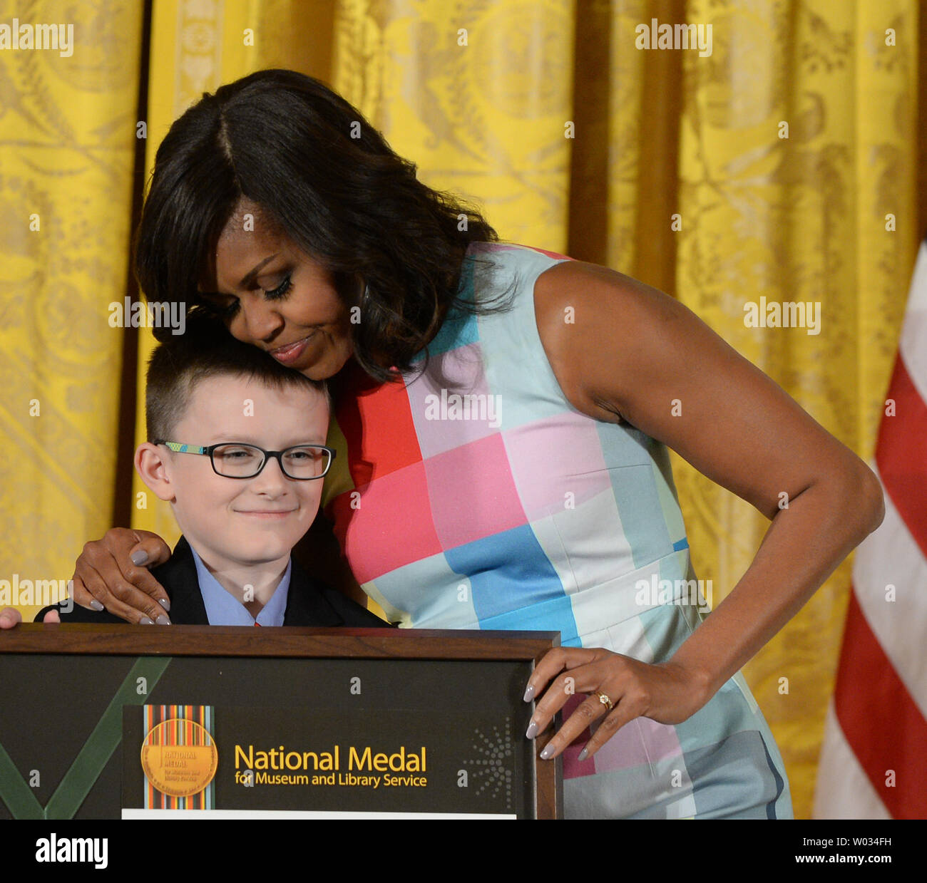 First Lady Michelle Obama hugs Colin Rice, community member of the