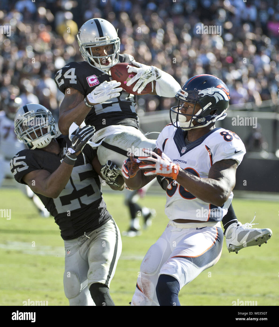 Oakland Raiders Charles Woodson (24) goes high to intercept a Denver Broncos Peyton Manning pass intended for Demaryius Thomas in the third quarter at O.co Coliseum in Oakland, California on October 11, 2015. The Broncos defeated the Raiders 16-10. Photo by Terry Schmitt/UPI Stock Photo
