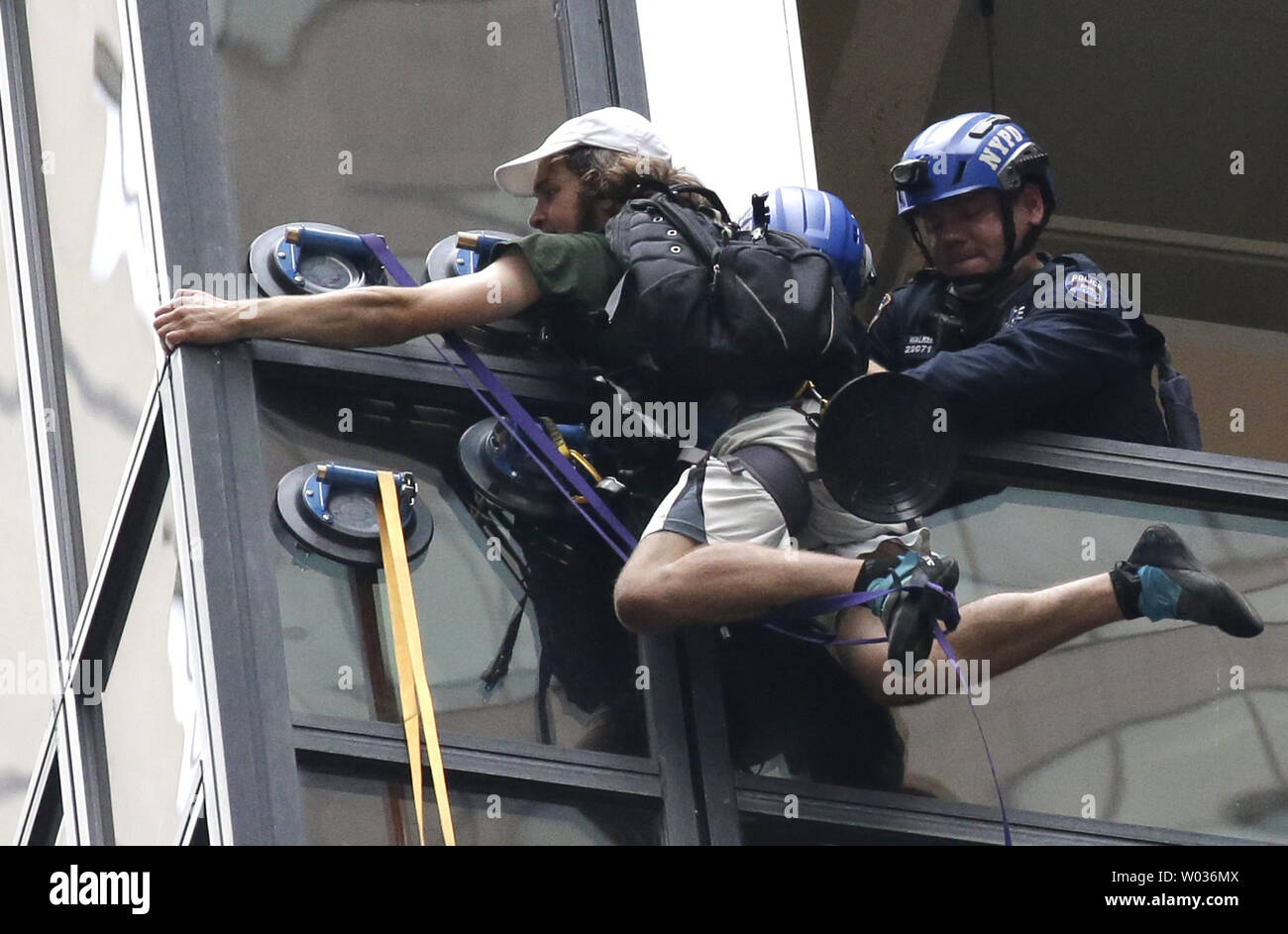 Police and rescuers pull a man, who had been scaling Trump Tower with suction cups, into the building on August 10, 2016 in New York City. The man, who police sources identified as Steve from Virginia, was grabbed by police through a busted out window pane from the 21st floor and pulled to Safety. Photo by John Angelillo/UPI Stock Photo