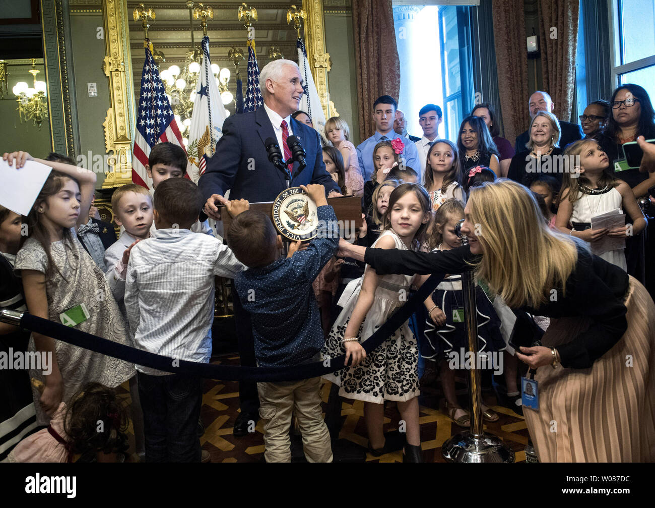 A child attempts to take the seal off of the lecture as Vice President Mike Pence delivers remarks to military families at an event recognizing National Military Appreciation Month and National Military Spouse Appreciation Day, in the Eisenhower Executive Office Building in Washington, D.C. on May 9, 2017. Photo by Kevin Dietsch/UPI Stock Photo