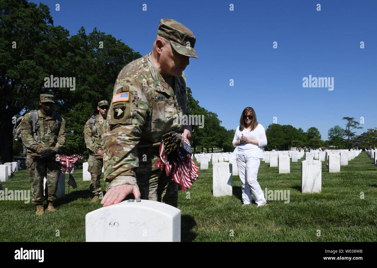 Four-Star General Mark Milley taps the gravestone after placcing a flag in front of the gravesite of Special Forces soldier Michael Yury Tarlavsky, who died in 2004 during the Iraq war, at Arlington National Cemetery during the 'Flags In' tradition in Arlington, Virginia on May 24, 2018.  Tarlavsky's wife Tricia is in the background. Milley is 39th Army Chief of Staff of the Army and the highest ranking military officer in the the Army. The 3rd U.S. Infantry Regiment (The Old Guard) has honored veterans for more than 60 years by placing flags at their gravesites. Photo by Pat Benic/UPI Stock Photo