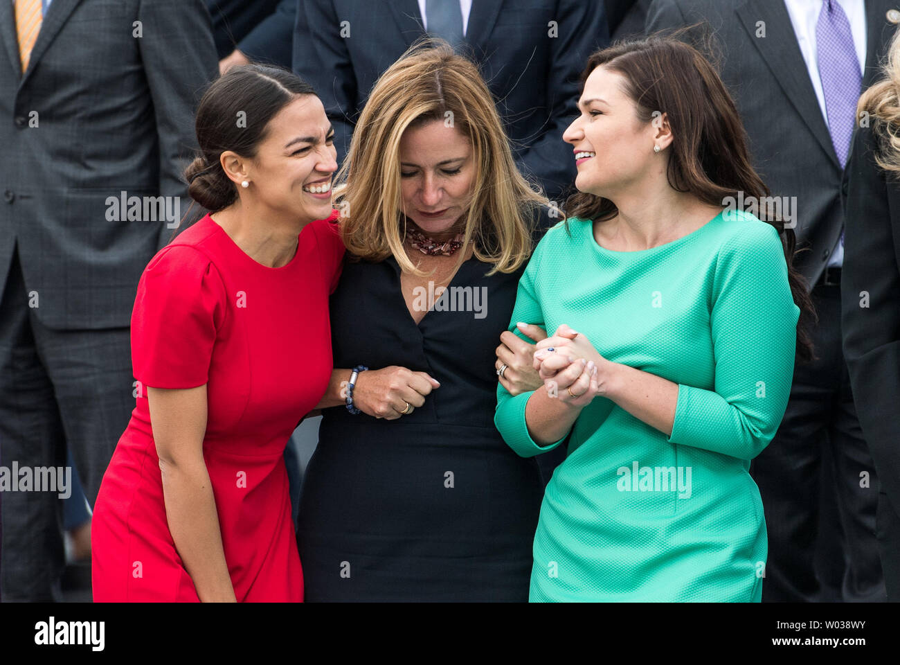 Representative-elects Alexandria Ocasio-Cortez, D-NY, (L), and Debbie Mucarsel-Powell, D-FL, (C), Abby Finkenauer,D-IA, huddle together to stay warm during the group photo for the new members of the upcoming 116th Congress, outside the U.S. Capitol Building in Washington, D.C. on November 14, 2018. Photo by Kevin Dietsch/UPI Stock Photo