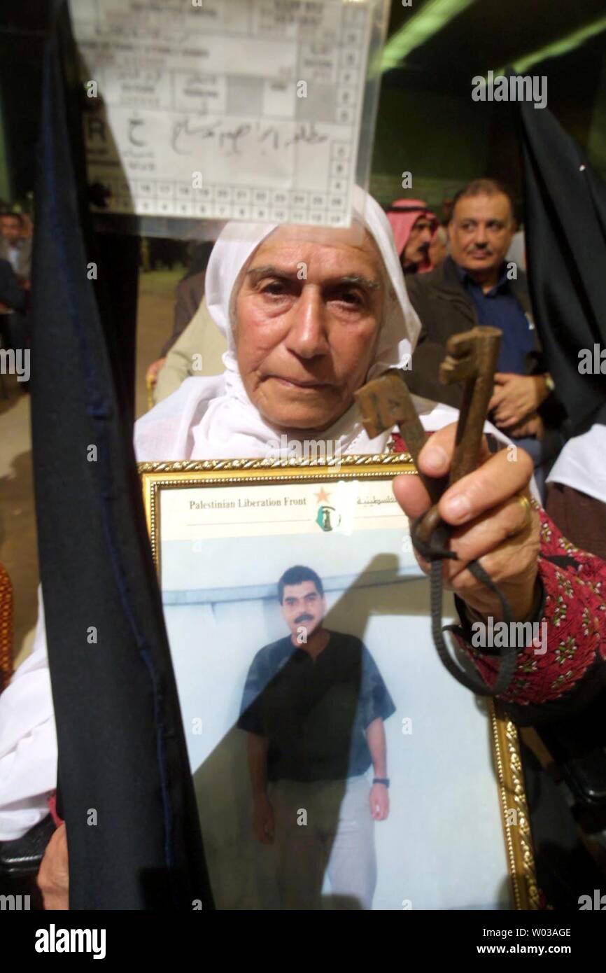 A Palestinian woman holds a picture of her son, who is being held in an Israeli jail at a gathering of groups opposed to against the Geneva Accord in Gaza City, Monday, Dec. 1, 2003. A symbolic Middle East peace plan dubbed 'the Geneva Accord' is due to be launched in a ceremony in Switzerland on Monday. By laying out steps to overcome longstanding obstacles to a 'two-state solution' in the Israeli-Palestinian conflict, the document goes beyond a U.S.-backed 'road map.'   (UPI photo/Ismael Mohamad ) Stock Photo