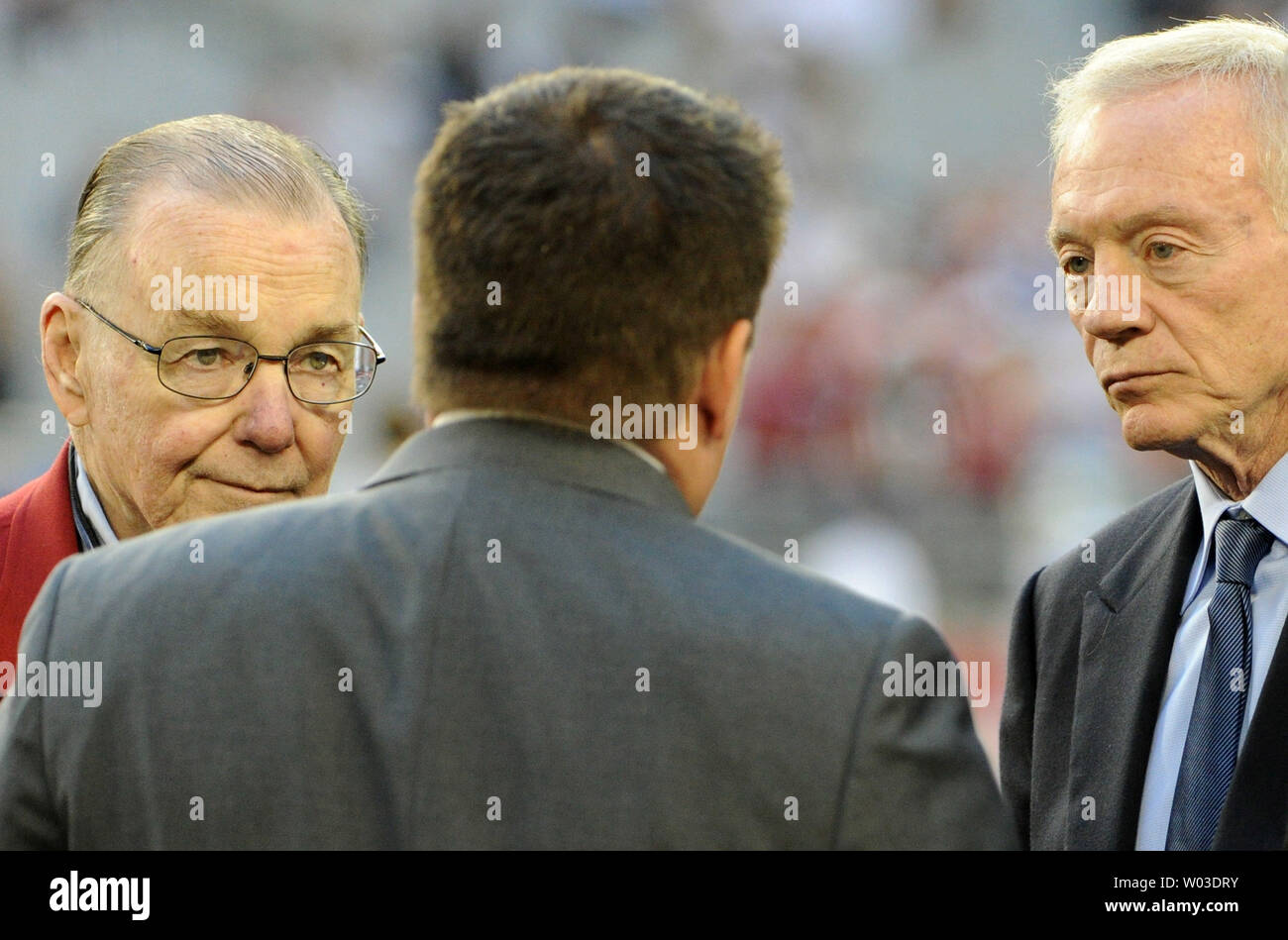 Arizona Cardinals owner Bill Bidwill (L) holds the George Halas Trophy as  commentator Terry Bradshaw (second from left,) interviews team president  Michael Bidwill (third from left) as coach Ken Whisenhunt (R) looks