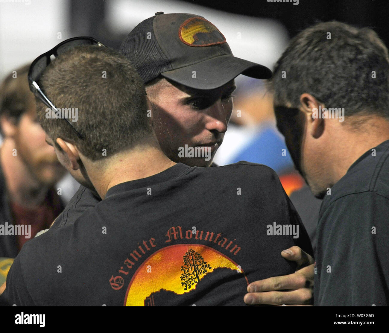 The lone survivor Brendan McDonough (C) gets a hug from another member