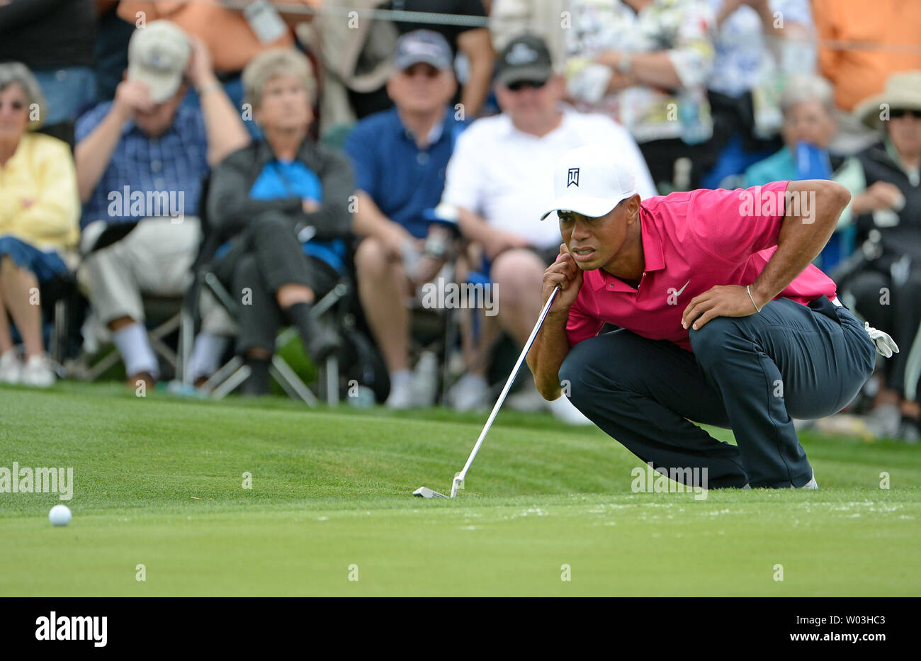 Tiger Woods looks at the line of his putt on the second hole of the