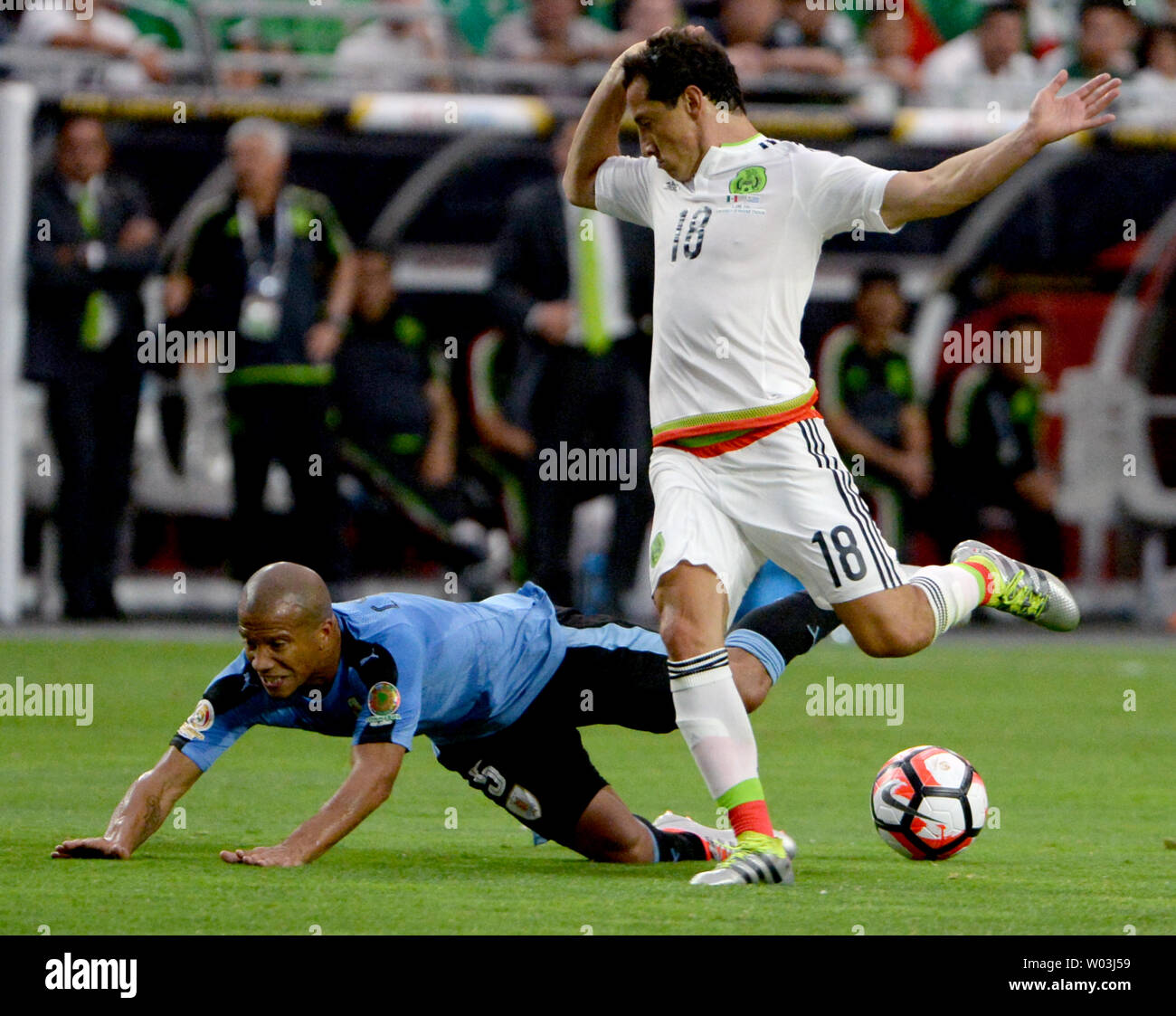 Mexico's Andres Guardado (R) trips up Uruguay's Carlos Sanchez in the second half of the Mexico-Uruguay match during the COPA America Centenario at University of Phoenix Stadium in Glendale, Arizona, June 5, 2016.        Photo by Art Foxall/UPI Stock Photo