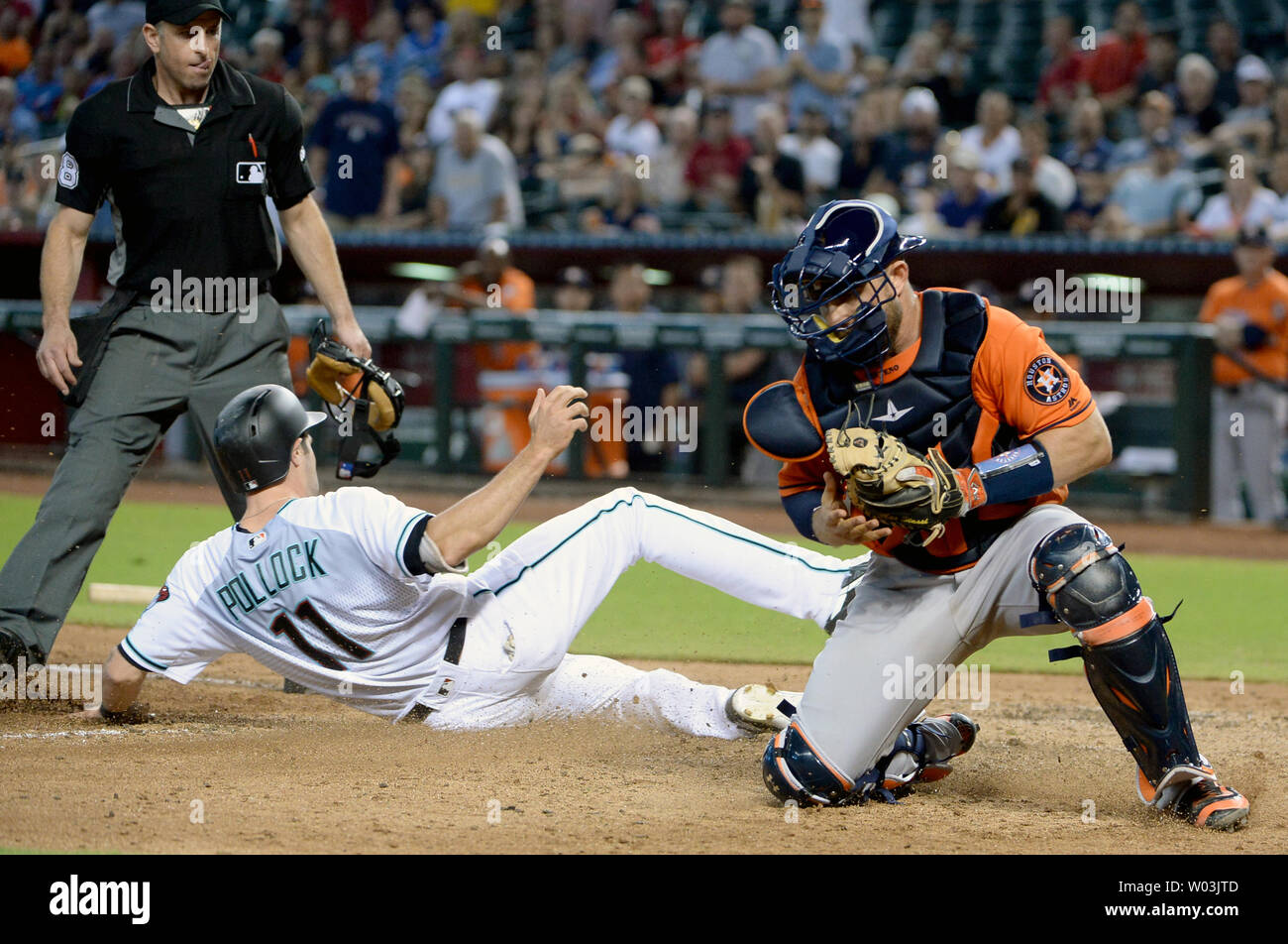 Arizona Diamondbacks' A. J. Pollock (C) slides in to home safely as Houston Astros' catcher Max Stassi fields the wide throw in the fourth inning at Chase Field in Phoenix, Arizona, August 15, 2017. Watching the play is home plate umpire Chris Guccione. The Astros defeated the Diamondbacks 9-4.     Photo by Art Foxall/UPI Stock Photo