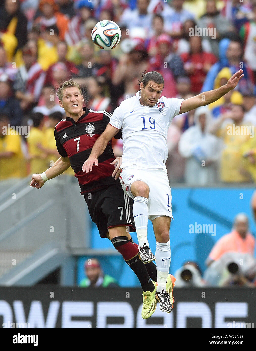 Graham Zusi of USA jumps for a header with Bastian Schweinsteiger (L) of Germany during the 2014 FIFA World Cup Group G match at the Arena Pernambuco in Recife, Brazil on June 26, 2014. UPI/Chris Brunskill Stock Photo