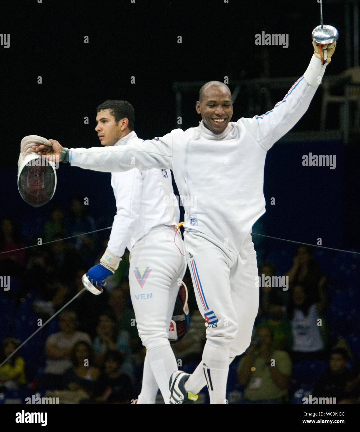 Venezuela's Reuben Limardo (L) looks to the referee as Cuba's Andres Carrillo celebrates a point in men's individual epee at Riocentro during the 2007 Pan Am Games in Rio de Janeiro, Brazil on July 16, 2007. Limardo went on to win gold, beating Carrillo 11-10 in overtime.  (UPI Photo/Heinz Ruckemann) Stock Photo