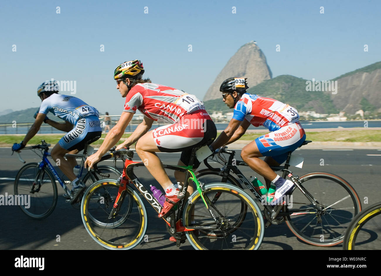 L. to R. Uruguay's Alen Reyes, Canada's Dominique Rollin and Dominican  Republic's Wendy Cruz race along the beach with Sugar Loaf mountain in the  background in men's road race cycling during the