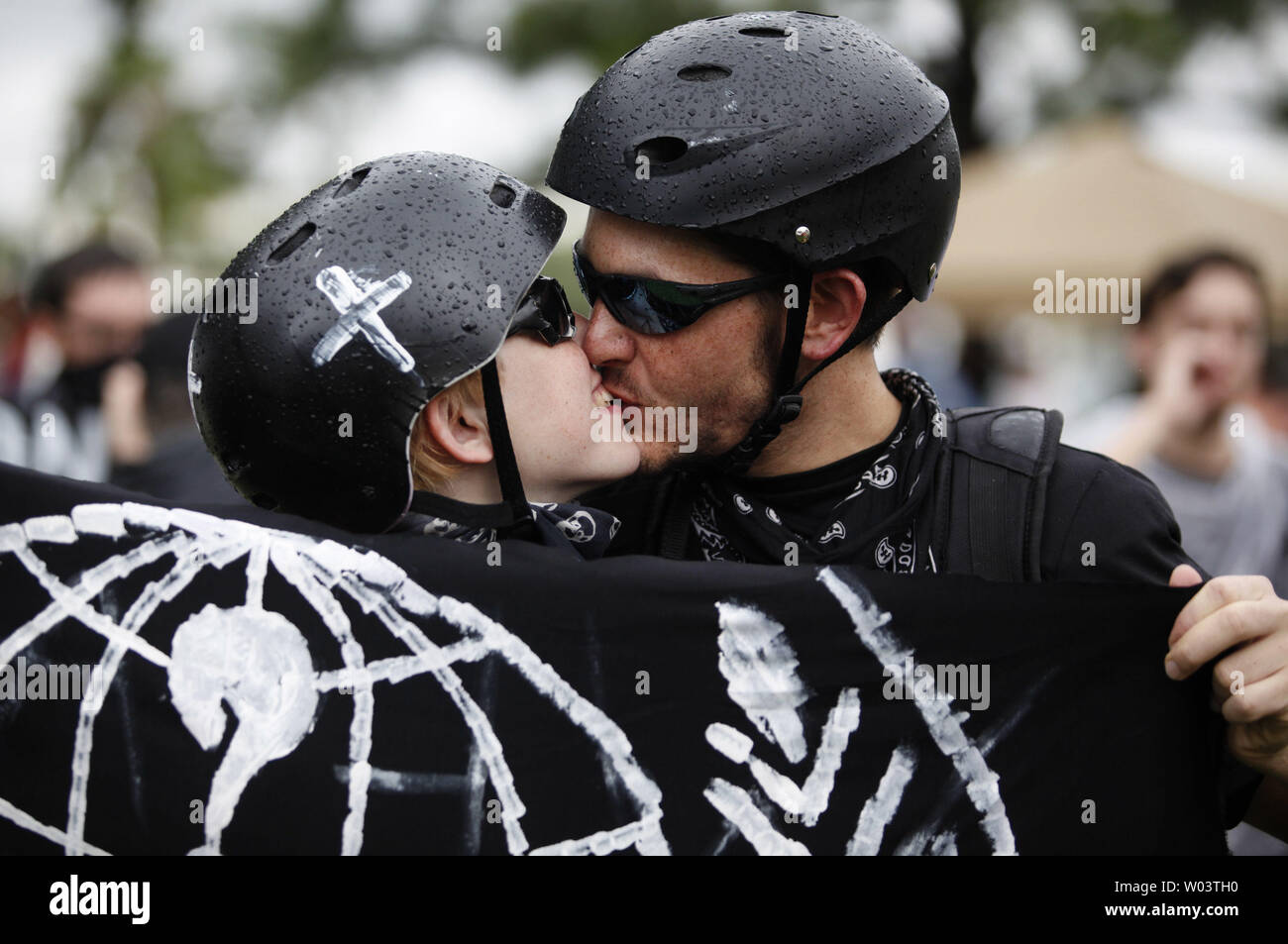 Protesters kiss one another at a rally by the Coalition to March on the RNC at Perry Harvey Park in Tampa, Florida on August 27, 2012.  The march is in response to the 2012 Republican National Convention which starts today in Tampa.  UPI/Matthew Healey Stock Photo