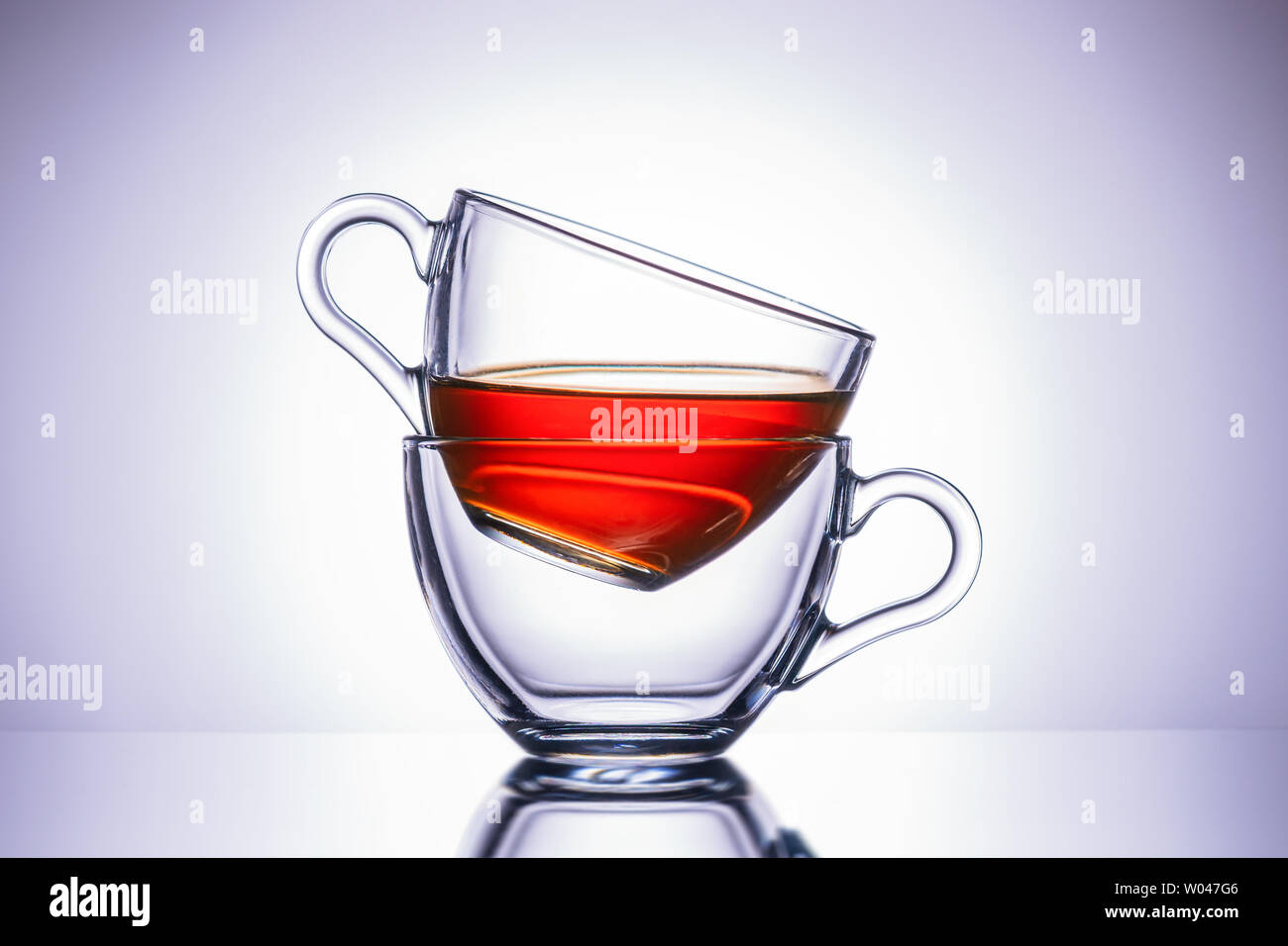 Two transparent mugs of tea. Central location, close-up. Stock Photo