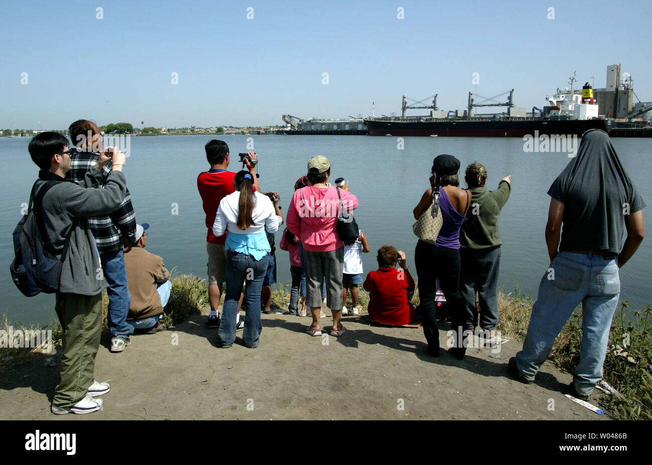 Local Sacramento residents watch as two humpback whales swims in the Port of Sacramento, West Sacramento, California, on May 17, 2007. Two humpback whales, a mother and her calf, swum up the deep water shipping channel to the Port of Sacramento late Tuesday. Experts will use underwater microphones emitting whale sounds in an attempt to lure the whales back out to the open ocean.   (UPI Photo/Ken James) Stock Photo
