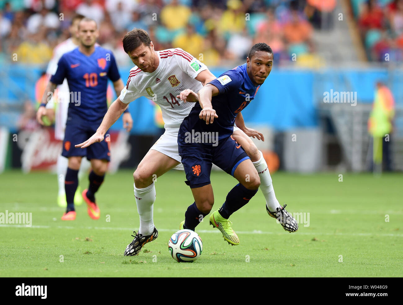Xabi Alonso of Spain (L) competes with Jonathan De Guzman of the Netherlands during the 2014 FIFA World Cup Group B match at the Arena Fonte Nova in Salvador, Brazil on June 13, 2014. UPI/Chris Brunskill Stock Photo