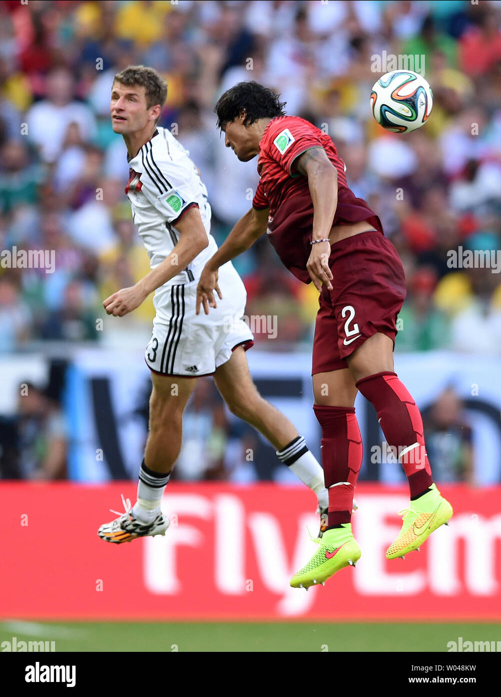 Thomas Muller of Germany jumps with Bruno Alves of Portugal during the 2014 FIFA World Cup Group G match at the Arena Fonte Nova in Salvador, Brazil on June 16, 2014. UPI/Chris Brunskill Stock Photo
