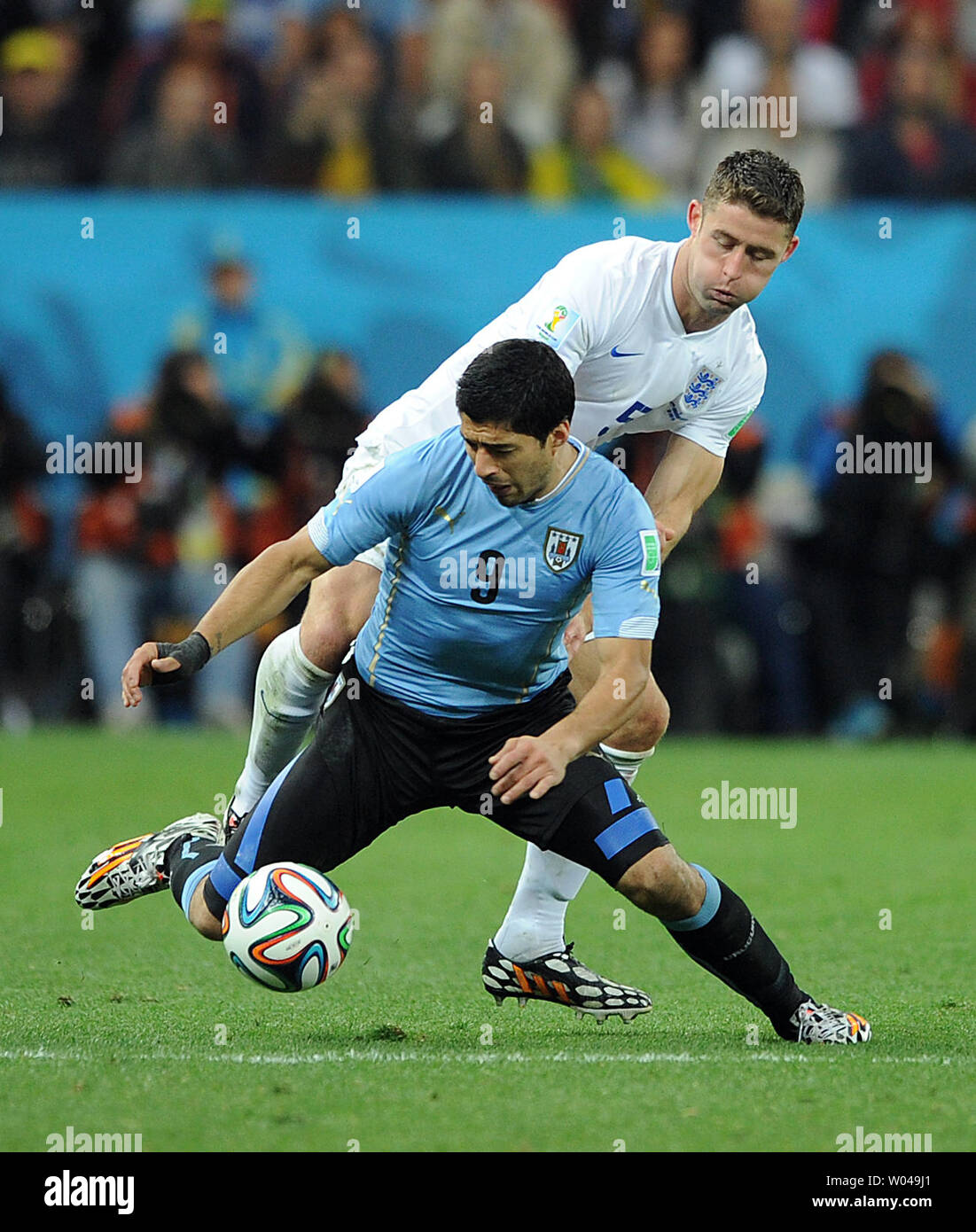 Luis Suarez (L) of Uruguay is fouled by Gary Cahill of England during the 2014 FIFA World Cup Group D match at the Arena Corinthians in Sao Paulo, Brazil on June 19, 2014. UPI/Chris Brunskill Stock Photo
