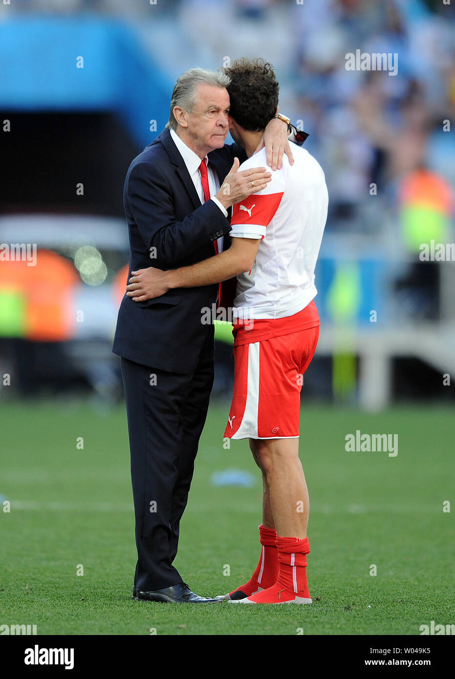 Switzerland manager Ottmar Hitzfeld consoles one of his players at full-time following the 2014 FIFA World Cup Round of 16 match at the Arena Corinthians in Sao Paulo, Brazil on July 01, 2014. UPI/Chris Brunskill Stock Photo