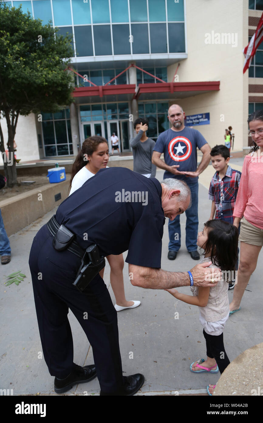 Dallas Police Assistant Chief Gary Tittle greets a little girl outisde police headquarters on Lamar Streer on July 9, 2016 in Dallas Texas. Days after a lone sniper opened fire on a peaceful 'Black Lives Matter' march killing five Dallas policemen.         Photo By Chris McGathey Stock Photo