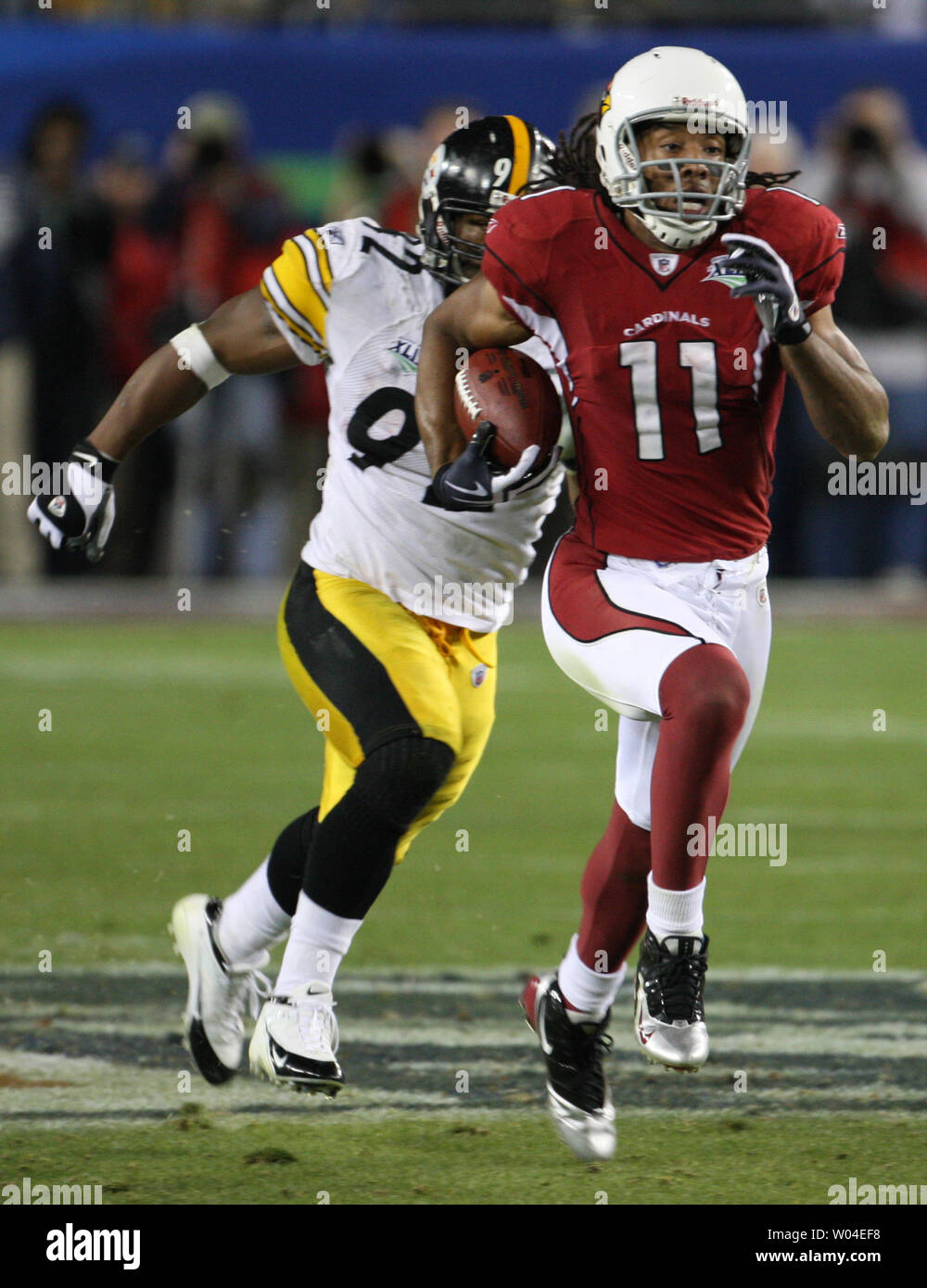 Pittsburgh Steelers linebacker James Harrison scores over Arizona Cardinals  wide receiver Larry Fitzgerald and Steve Breaston (15) on a Super Bowl  record 100-yard interception returned for a touchdown during the second  quarterat