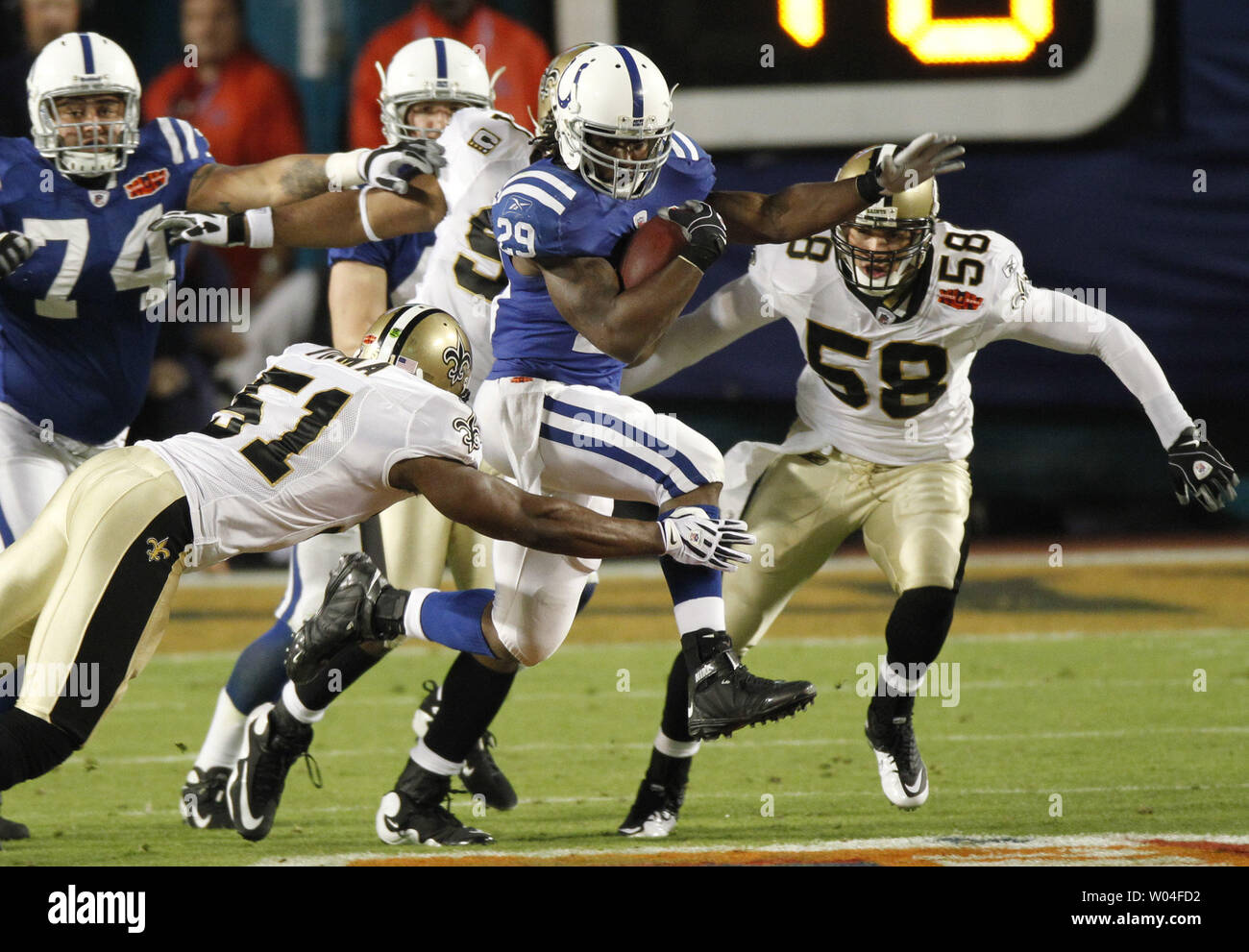Indianapolis Colts running back Joseph Addai (C) runs against New Orleans  Saints linebackers Jonathan Vilma (51) and Anthony Waters (59)during the first  quarter at Super Bowl XLIV in Miami on February 7
