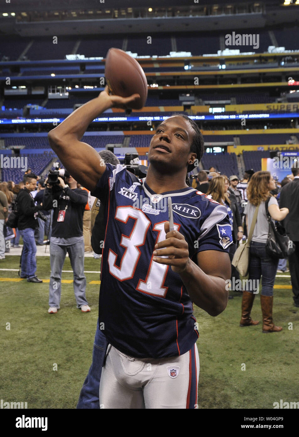 New England Patriots free safety Sergio Brown throws a ball back into the stands after signing an autograph for a fan on Media Day during Super Bowl week on January 31, 2012