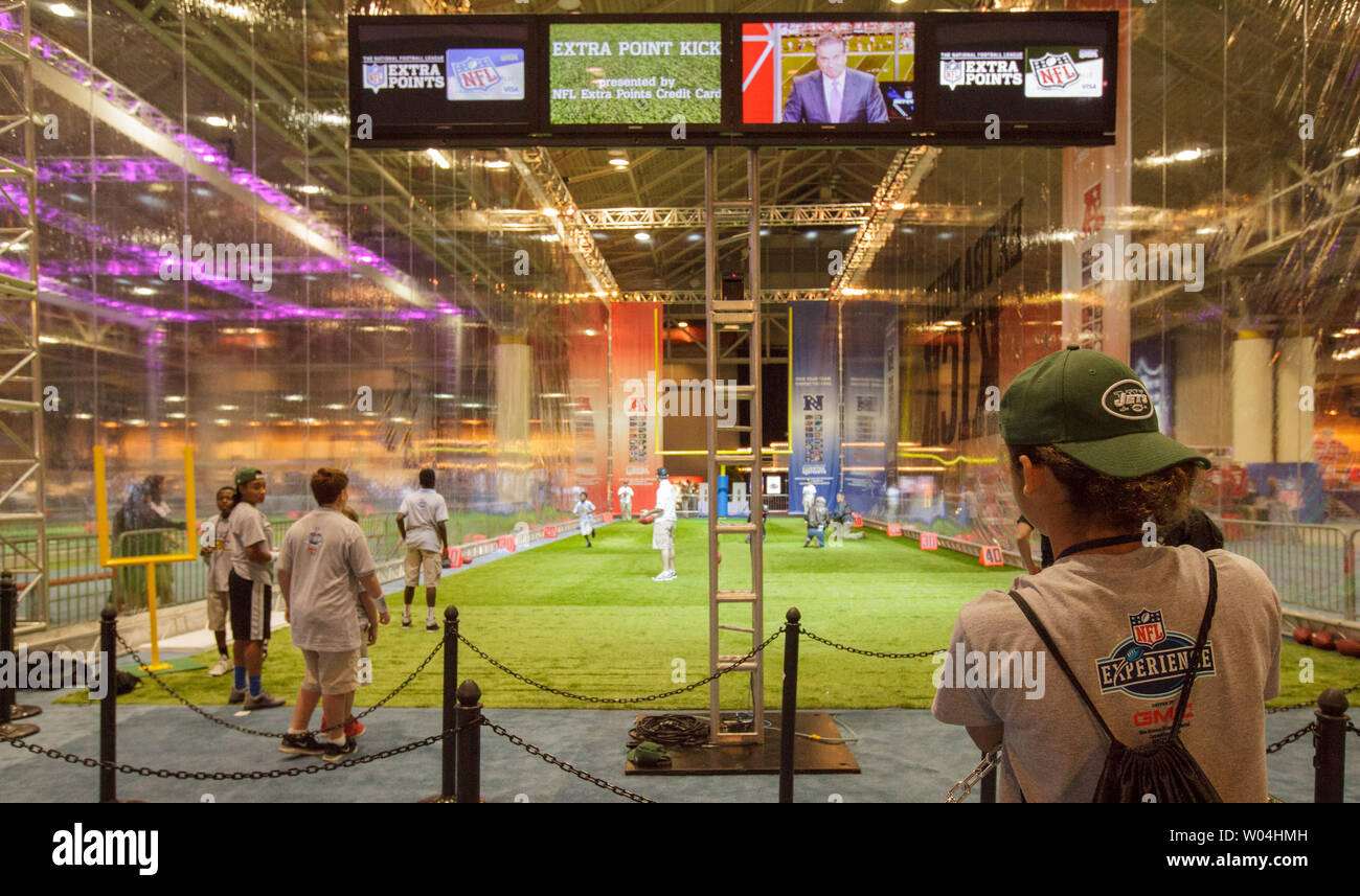 Kids practice throwing a football at the NFL Experience prior to