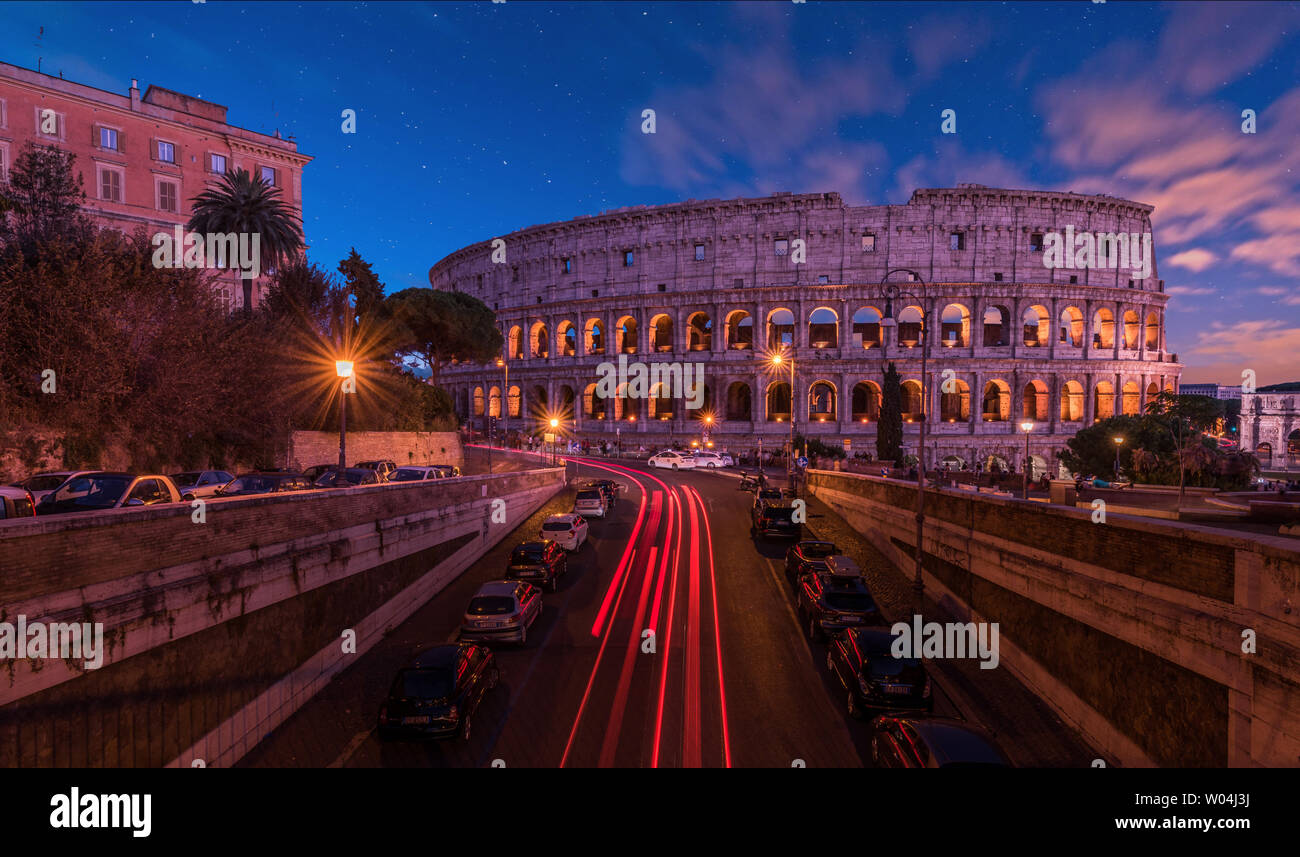 The Colosseum building is impressive both for the day and for the evening clock. The sky is clear, full of stars, the city darned by the world, touris Stock Photo
