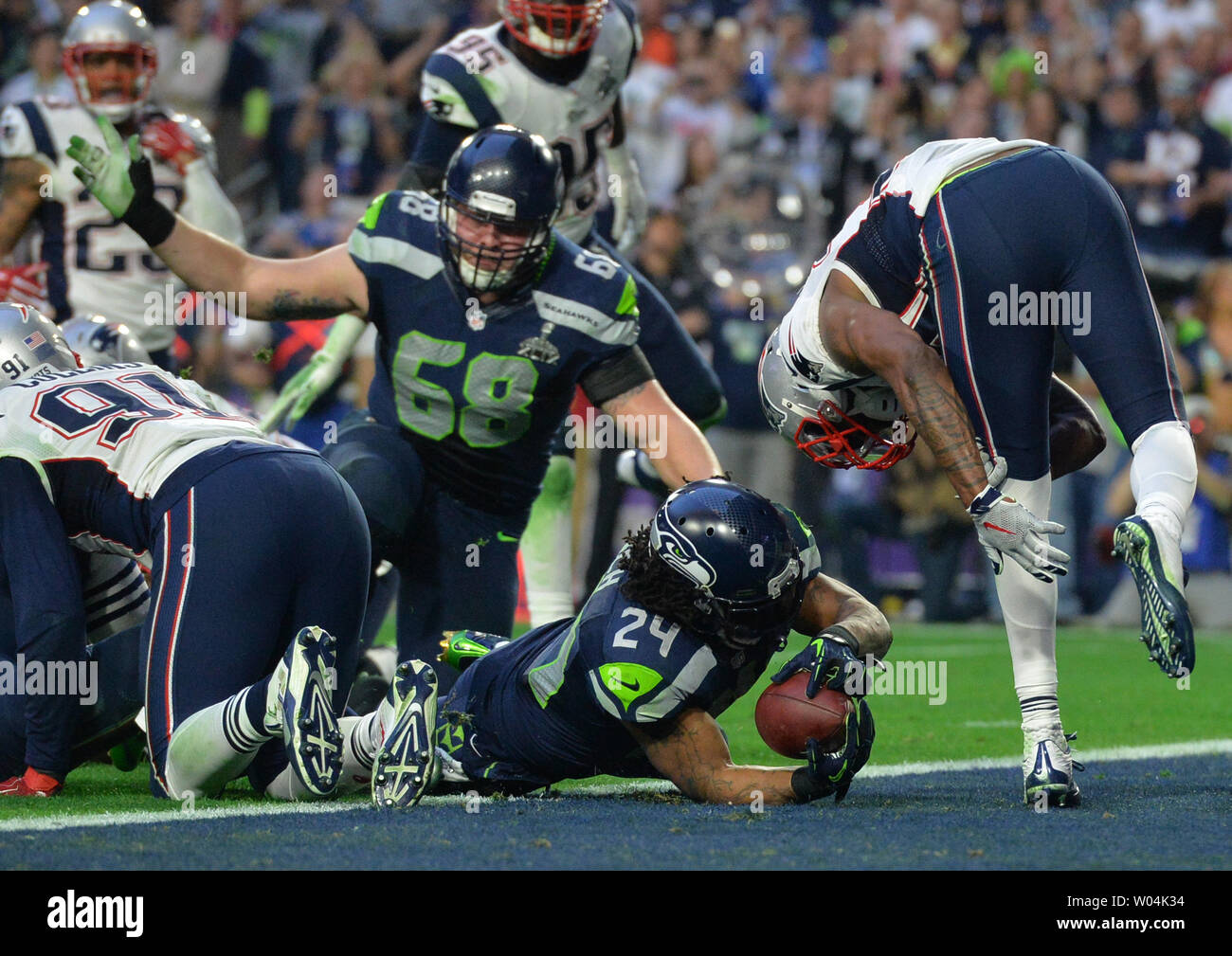 Seattle Seahawks Marshawn Lynch (24) pushes the ball over the goal line for  a three yard TD against the New England Patriots in the second quarter of  Super Bowl XLIX at University