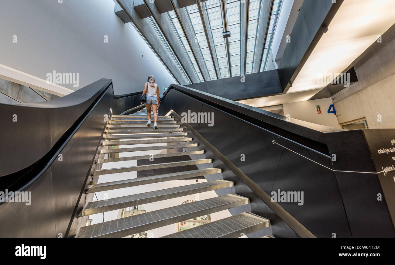 Stairs that you enjoy climbing. The person in the photo is surprised while doing it, looking very interested and eager to get to the top. Stock Photo