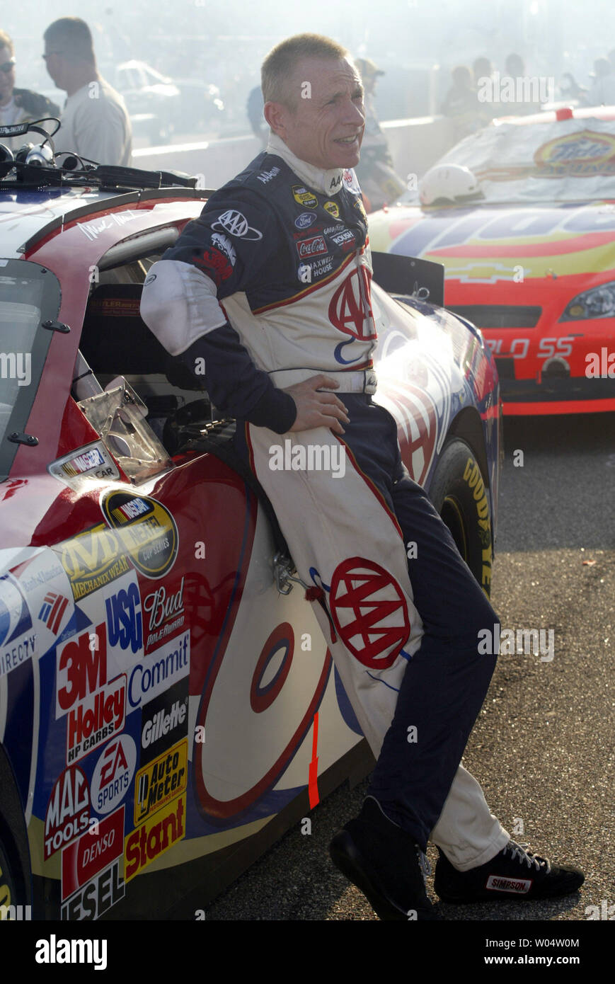 Race car driver Mark Martin stands by his car on pit road as he awaits ...