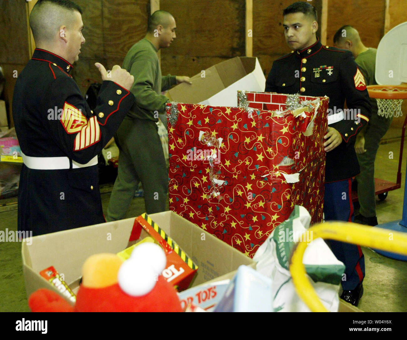 Marine Staff Sgt. Alfonso Torres (left) and Sgt. Joaquin Montanez (in dress blues) move toys to the recreation center for distribution to children on Christmas eve at Camp Pendleton Marine Base, San Diego, California, December 24, 2003. UPI Photo/Roger Williams Stock Photo