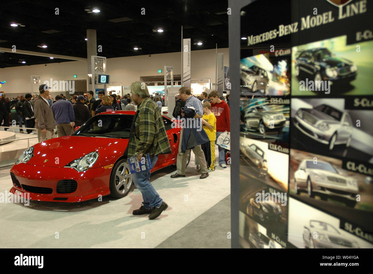 Visitors to the San Diego International Car Show look at a 2005 Porsche 911 Turbo S Cabriolet as well as some of the over 250 2005 and 2006 model vehicles on display at the San Diego Convention Center on December 31, 2004 in San Diego California. The auto show will attract over three hundred thousand people and is the six largest in the country, showcasing concept cars and new releases from the top automakers. ( UPI Photo/Earl S. Cryer) Stock Photo