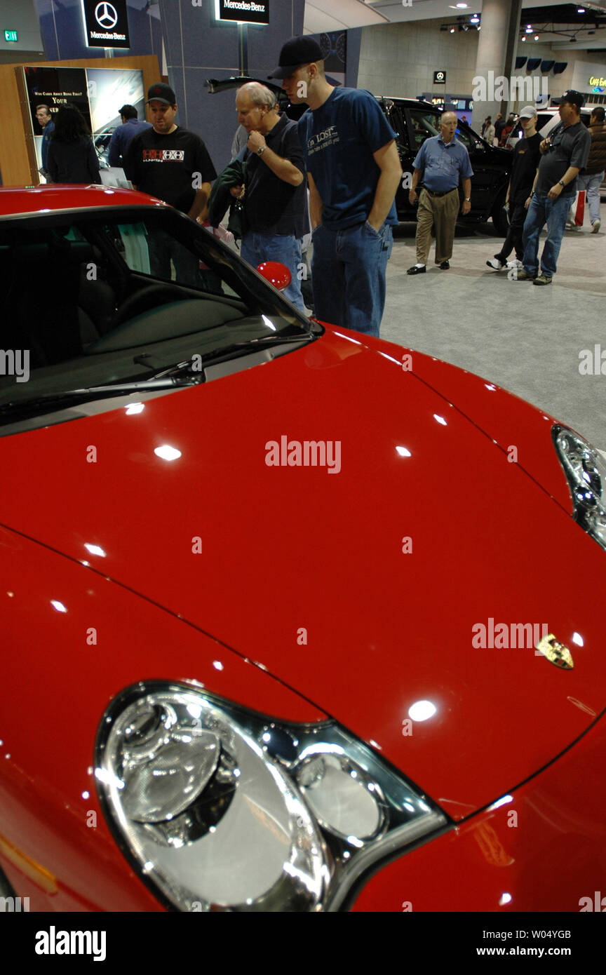 Visitors to the San Diego International Car Show look at a 2005 Porsche 911 Turbo S Cabriolet as well as some of the over 250 2005 and 2006 model vehicles on display at the San Diego Convention Center on December 31, 2004 in San Diego California. The auto show will attract over three hundred thousand people and is the six largest in the country, showcasing concept cars and new releases from the top automakers. ( UPI Photo/Earl S. Cryer) Stock Photo