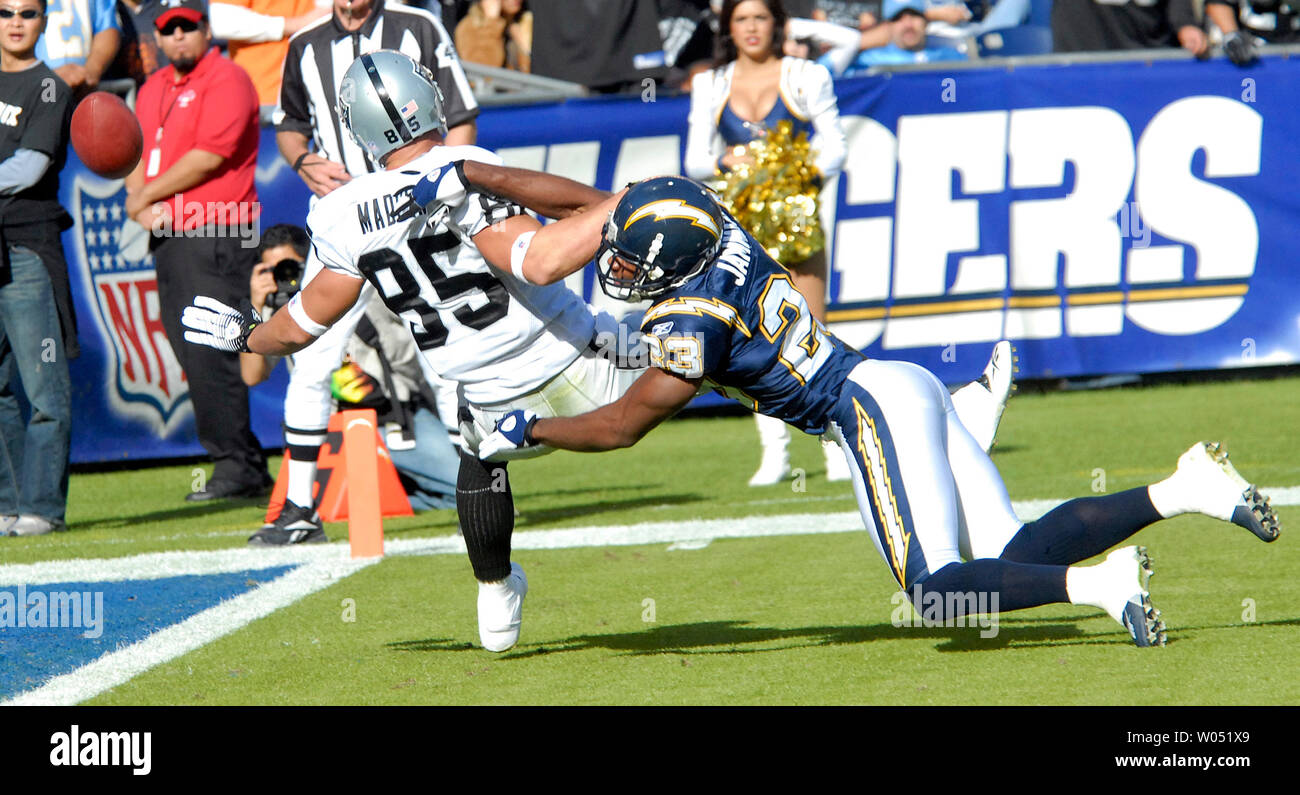 Oakland Raiders wide receiver John Madsen (85) is tackled by San Diego  Chargers cornerback Quentin Jammer (23) at Qualcomm Stadium in San Diego on  November 26, 2006. Jammer was called for interference