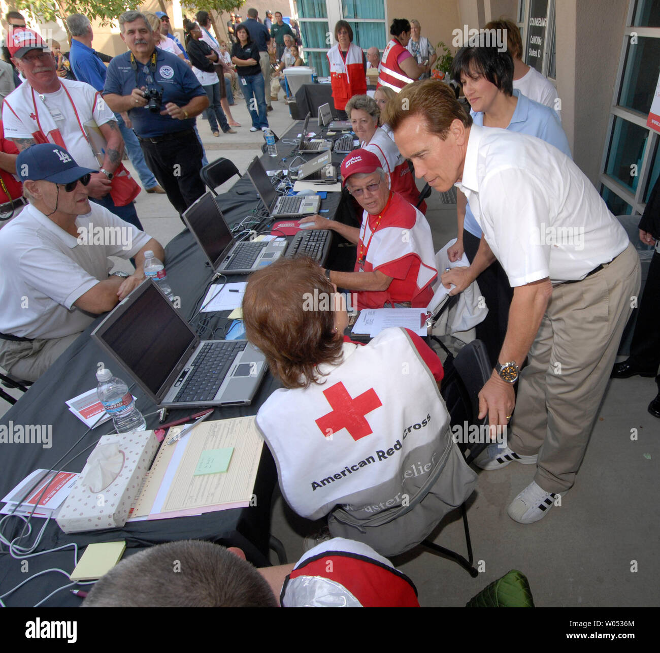 California Governor Arnold Schwarzenegger speaks with  Red Cross workers at an Assistance Center set up in Rancho San Diego, California to help victims of the wildfires, on October 28, 2007. The Harris Fire killed 5 people, forced thousands to evacuate and destroyed hundreds of homes.  (UPI Photo/Earl Cryer) Stock Photo