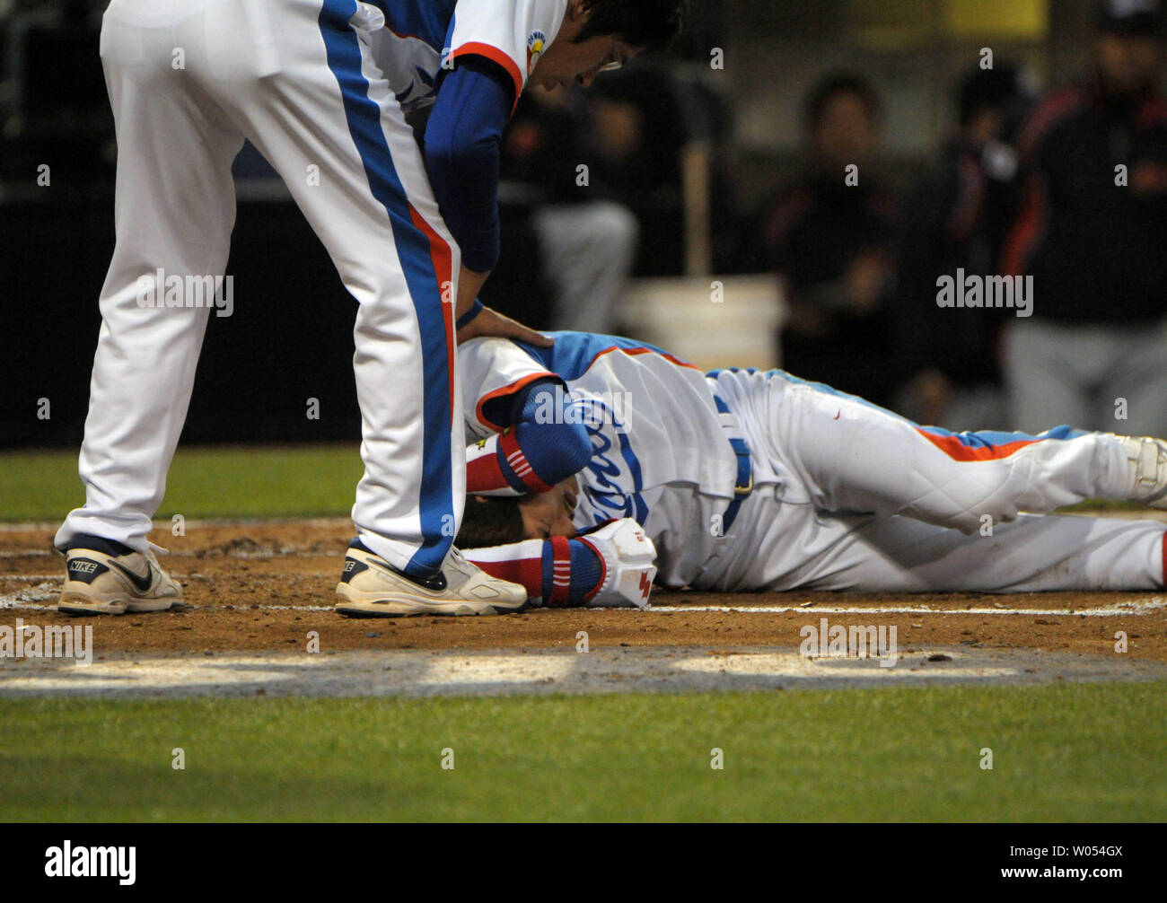 Lee Yong-Kyu of Team Korea holds his head after being hit by a pitch during the third inning against Team Japan during Round 2 of the World Baseball Classic in San Diego, March 19, 2009.  ( UPI Photo/Earl S. Cryer) Stock Photo