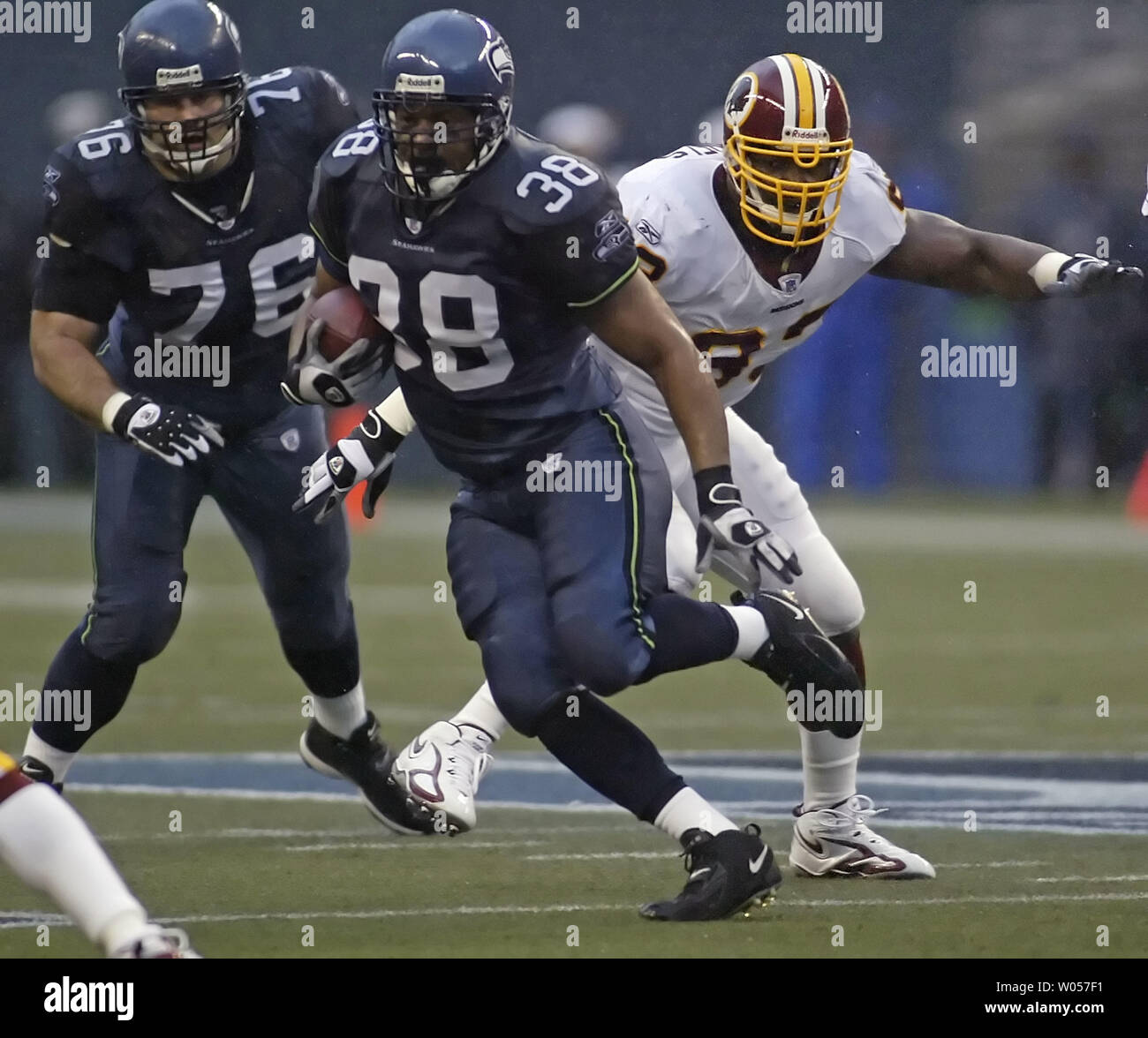 Seattle Seahawks fullback Mack Strong , center, runs for short yardage as  Washington Redskins' Phillip Daniels ,right, follows during the first  quarter of NFL action in Seattle on January 14, 2006. Seahawks