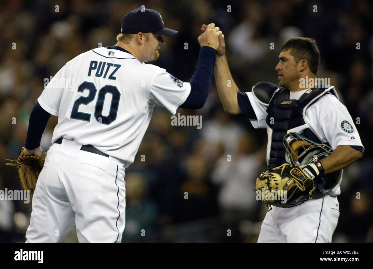 Seattle Mariners' closing pitcher J.J. Putz, left, grabs the hand of