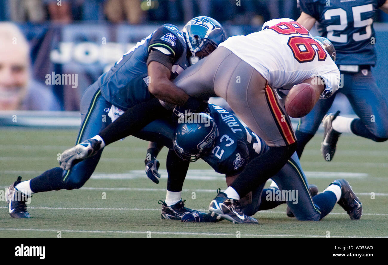 Tampa Bay Buccaneers Jerramy Stevens (R)  looses the ball while being tackled by Seattle Seahawks strong safety Jordan Babineaux (L)  and corner back Marcus Trufant (23) in the fourth quarter at Qwest Field in Seattle on September 9, 2007. The ball was recovered by Babibeaux. The Seahawks beat the Buccaneers 20-6 in their season opener. (UPI Photo/Jim Bryant) Stock Photo