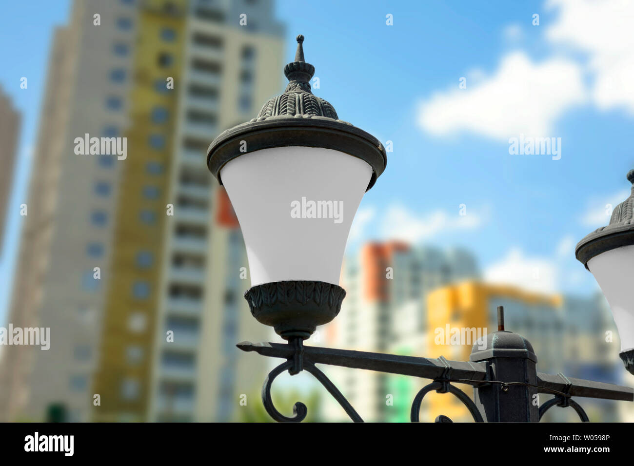 Cast iron street lamps on blurred background with modern multicolored