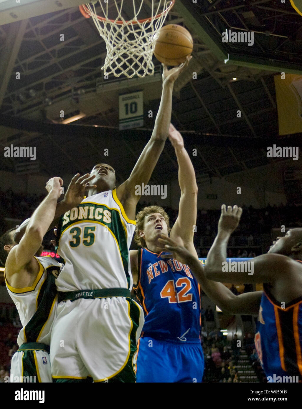 Seattle SuperSonics' Kevin Durant (35) is fouled by New York Knicks' David Lee (42) as he scores a layup during the second half at the Key Arena in Seattle on February 2, 2008. Durant led the SuperSonics with 21 points in their 86-85 win over the New York Knicks. Also defending against Durant is Knicks Zach Randolph (R). (UPI Photo/Jim Bryant) Stock Photo