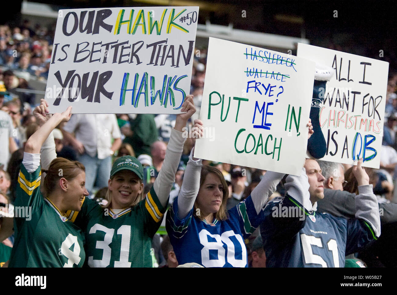 Green Bay Packers'  fans Alice Martin, left, and Bobby Nelms display their signs next to Seattle Seahawks' fans Marsha and Alan Martin as they holds up their signs in the first quarter at Qwest Field in Seattle on October 12, 2008. An injury to starter Matt Hasselbeck and a strained calf muscle to backup Seneca Wallace, opened the door for Charlie Frye, who made his first regular-season start as a Seattle Seahawks today. Frye completed 12 of 23 passes for  83 yards and two touchdowns and two interceptions in the Seahawks 17-27 loss to the Packers. (UPI Photo/Jim Bryant) Stock Photo