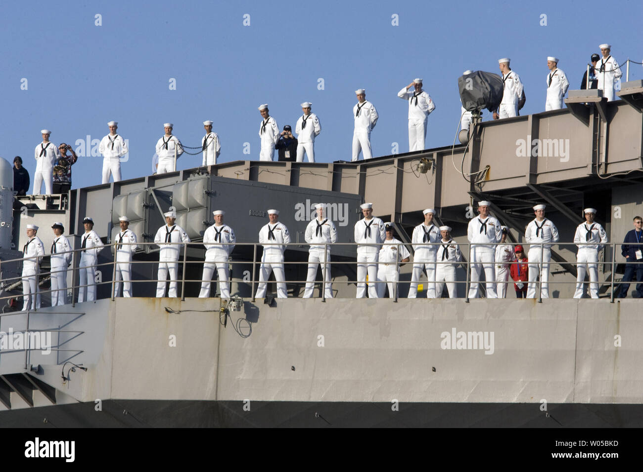 USS John C. Stennis crew members man the rails as the 1,092-foot-long