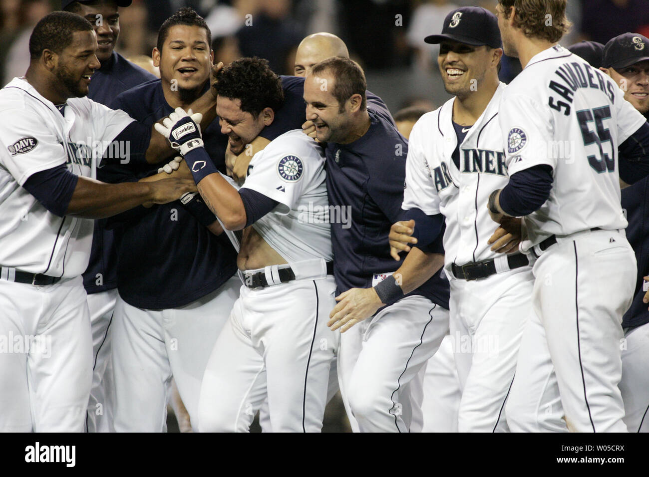 Seattle Mariners Luis Rodriguez is mobbed by Felix Hernandez and other teammates after hitting a led off the bottom of the 12th inning  solo homer to give the Mariners a 2-1 win over the Yankees at Qwest Field in Seattle, Washington, on September14, 2011. UPI/Jim Bryant Stock Photo